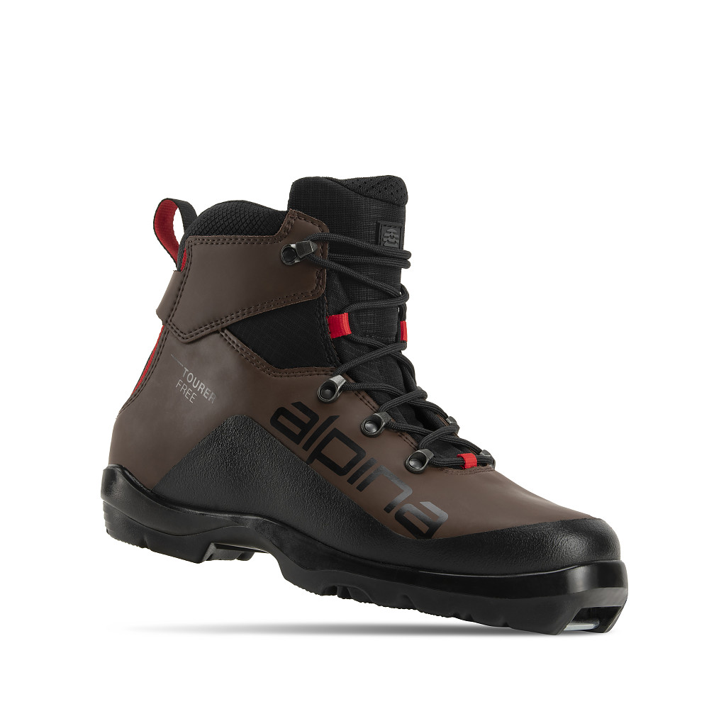 Alpina Tourer Free cross-country ski boot for recreational off-track touring. The mid-cut boot combines tan and black synthetic materials with red details and a rugged outsole for grip on mixed terrain. Lightweight, water-resistant, and insulated for comfort and freedom of movement in winter conditions.