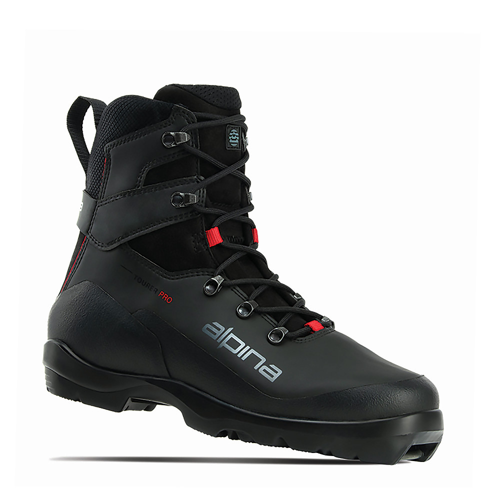 Alpina Tourer Pro ski boot, designed for cross-country skiing with added ankle support and durability. The high-cut black boot features reinforced heel and ankle areas, red lace accents, and a prominent Alpina logo. Engineered for stability and comfort on groomed or variable terrain, with water-resistant construction and light insulation.
