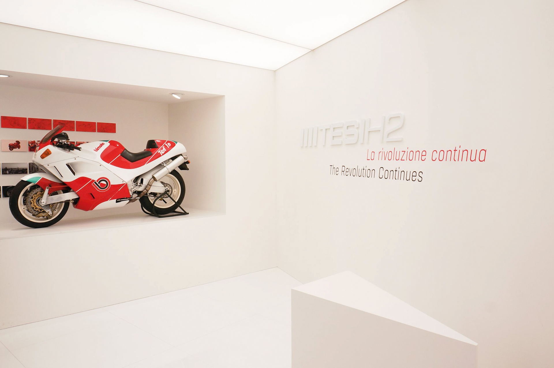 A photo from the Eicma show 2019 in Milano, from the Bimota presentation of the new Tesi H2 motorcycle, showing the wall with the Tesi H2 and the slogan “The Revolution Continues” graphics.