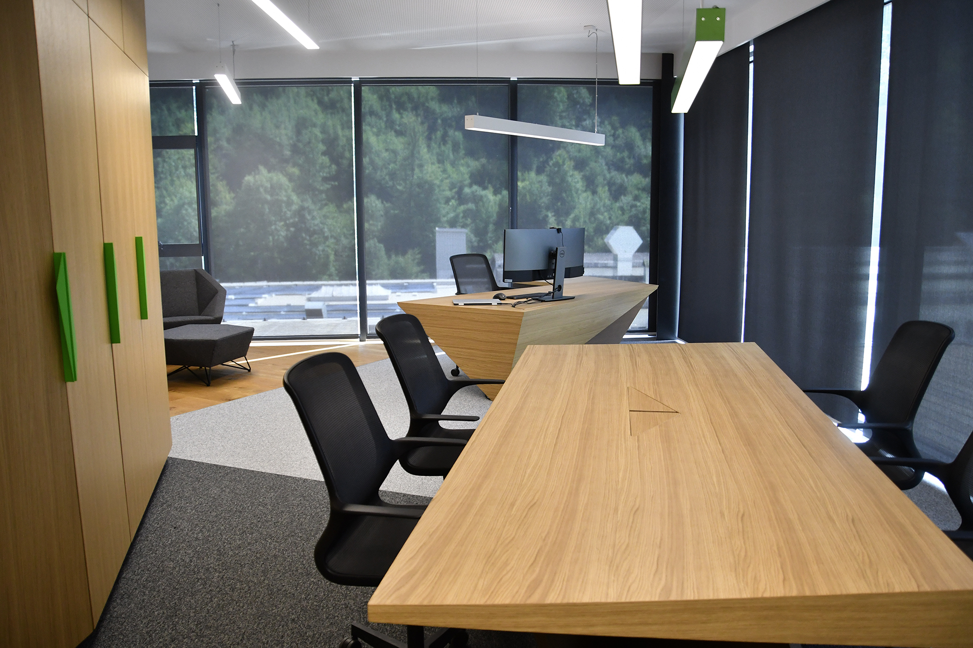 A photo of the Mebor company executive office space interior design, showing the conference table and, in the background, the executive desk.