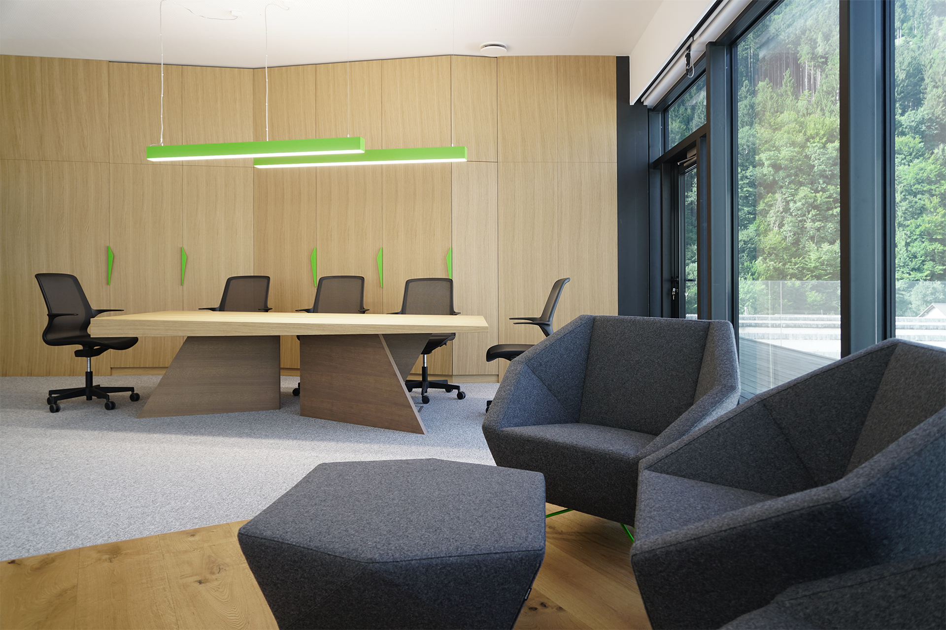 A photo of the Mebor company executive office space interior design, showing custom conference table and lounge seating in the front.